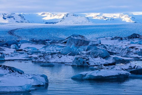 Snow-covered icebergs in the glacier lagoon Jökullsarlon, Breidamerkurjökull in the background,