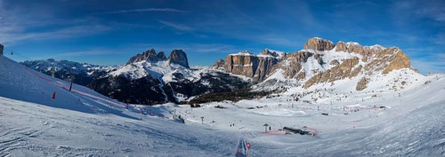 Panorama of a ski resort piste with people skiing in Dolomites in Italy. Ski area Belvedere.