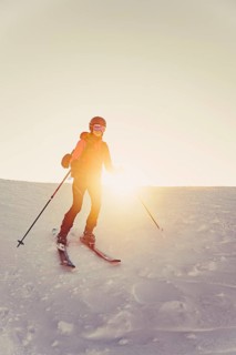 A woman's ski tour at sunrise on the Tegelberg in the Allgäu in the Ammergebirge, Bavaria, Germany,
