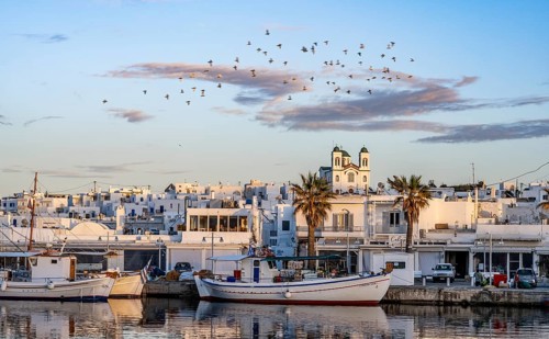 View of Naoussa, Fishing boats in the harbour at sunset, reflected in the sea, White Cycladic