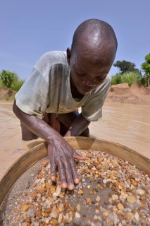 Diamond hunter searching for diamonds with a sieve, near Koidu, Koidu-Sefadu, Kono District,