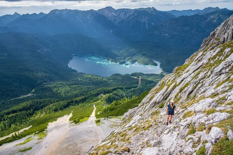 Via ferrata over the Riffelscharte, hiker in the mountains, view of Eibsee lake and Werdenfelser