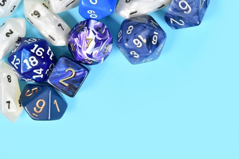 Different roleplaying RPG dice in upper corner of blue background with blank copy space