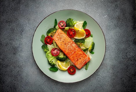 Grilled salmon fillet, with vegetables, broccoli, cherry, iceberg lettuce, spices and herbs,