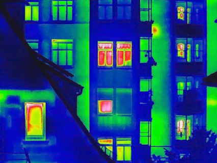 Apartment block, facade of a residential building with windows. Thermal image or thermography,