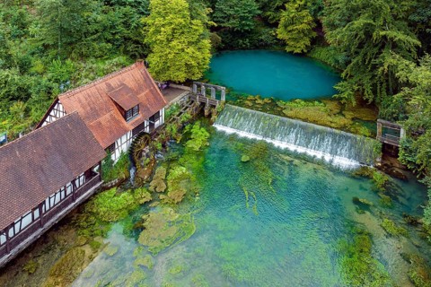 Blautopf Blaubeuren with industrial monument Hammerschmiede, source of the little river Blau in a