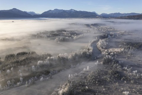 Aerial view of a moor landscape with river in front of mountains in winter, hoarfrost, morning