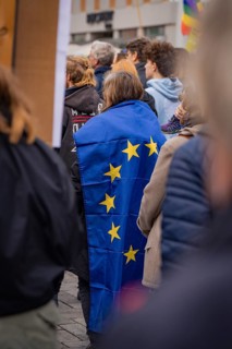 Person wearing an EU flag as a cloak at a public gathering, Against the Right Demo, Nagold, Black