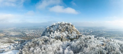 Aerial panorama of the snow-covered Hegau volcano Hohentwiel with Germany's largest castle ruins,