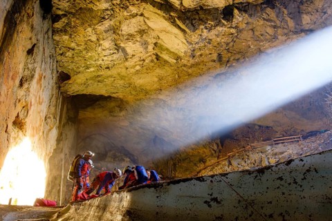 Sunbeam shines into the cave, cave rescuers from the Bavarian Mountain Rescue Service rescue an