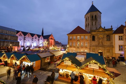 Christmas market stalls at the market, behind St Ulrich's Church and Paderborn Cathedral, blue