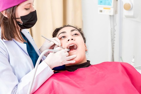 View of a dentist cleaning a patient mouth with a drill. Stomatologist cleaning a patient's teeth,