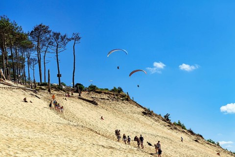 Two paragliders approaching, walkers, tourists on dune, Dune du Pilat, view from below, Arcachon,