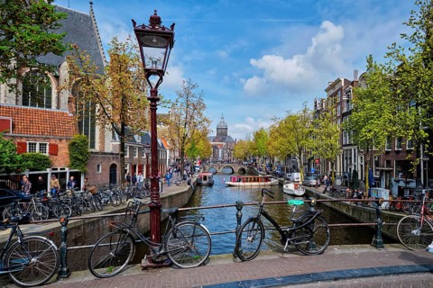 AMSTERDAM, NETHERLANDS, MAY 7, 2017: Bicycles in Amsterdam street on bridge over canal with old