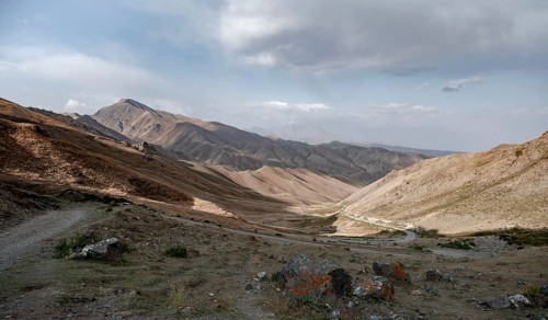 View of mountain landscape and pass road at Tyibel Pass, Song Kul Too mountain range, Naryn region,