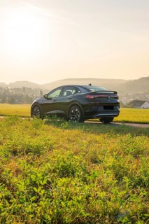 SUV on a rural road with a view of the hills in the background, at sunset, VW ID5 electric car,