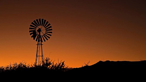 A wind-powered water pump at sunrise, Namibia, Africa