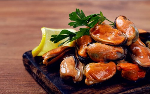 Mussels without shell, boiled, mussels, peeled, on a chopping board, with lemon and parsley,