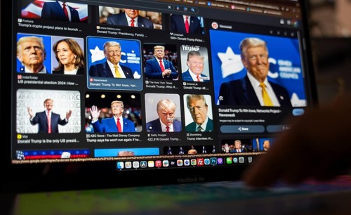 In this photo illustration, a person looks Donald Trump news on a laptop after results of U.S.