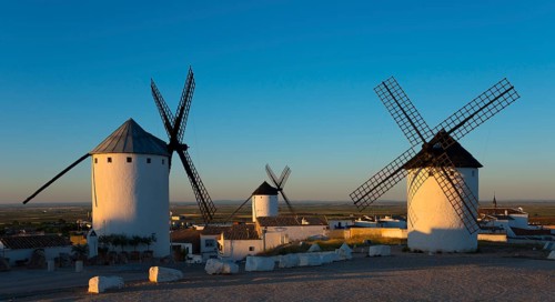 Three white windmills in a sunny landscape at sunrise in Spain, Campo de Criptana, province of