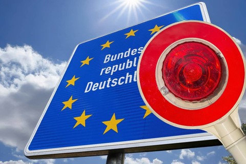 Symbolic image of the asylum debate: trowel in front of a border sign of the Federal Republic of