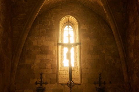 Chancel of the monastery church, window of a church with sunlight on a cross, Gothic style,
