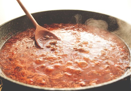 Cooking, bolognese sauce, in a frying pan, stirring with a wooden spoon, tomato meat sauce,