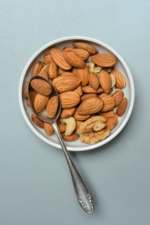 Almonds and walnuts in shell with spoon, various nuts