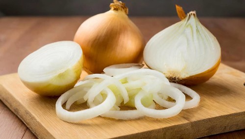Vegetables, onion, Allium cepa, freshly sliced onion rings and finely chopped onion on a wooden