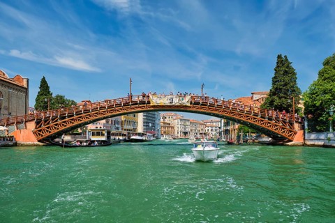 VENICE, ITALY, JULY 19, 2019: Ponte dell'Accademia bridge with boat passing under on Grand Canal,