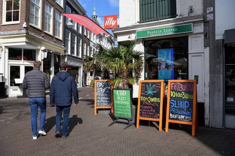 Passers-by in front of a cannabis shop in the pedestrian zone of The Hague, Holland, Netherlands
