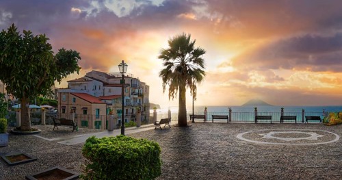 Belvedere Piazza del Cannone town square at sunset and Stromboli volcano in the sea in the