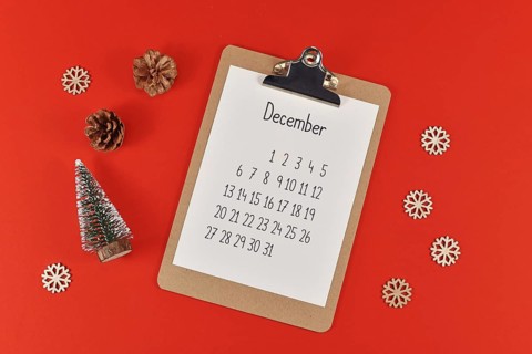 Christmas flat lay with clipboard with calendar sheet for month December surrounded by small