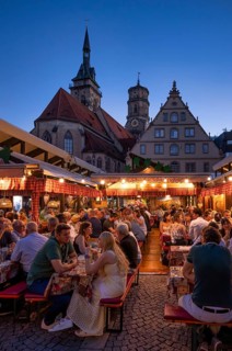 People sitting in wine arbours in the evening, Weindorf Stuttgart, Schillerplatz, collegiate
