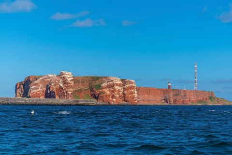 Red red sandstone cliff edge, Heligoland high sea island, North Sea, lighthouse, radio tower, blue