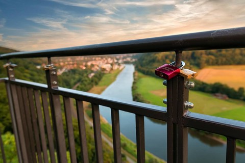 Two love locks on the railing, view from the skywalk onto the Weser towards Bad Karlshafen in the