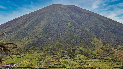 Green volcanic mountain, Monte dei Porri, vineyards, fields, sky exchanged, Valdichiesa, Salina,