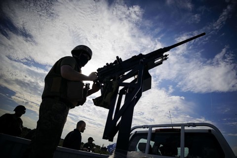 A soldier from a Mobile Air Defence unit stands at a machine gun mounted on a pickup truck. Kyiv,