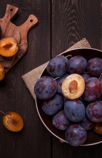 Blue plum, on a wooden table, top view, close-up, no people