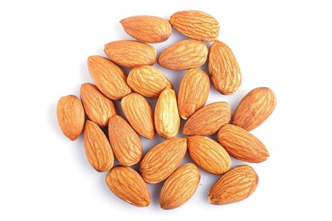 Pile of almonds isolated on white background. top view