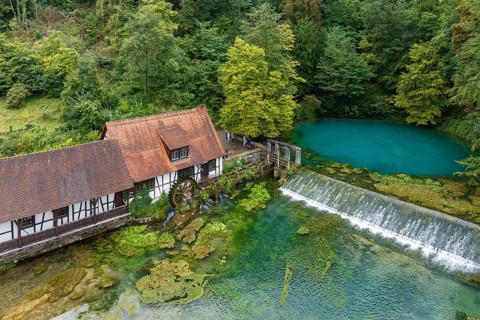 Blautopf Blaubeuren with industrial monument Hammerschmiede, source of the little river Blau in a