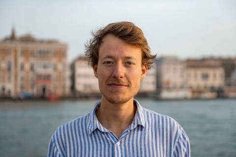 Young man in striped shirt, portrait, on the banks of the Grand Canal, looking into the camera,