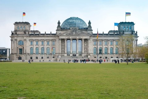 The Reichstag building in Berlin with visitors in front of it, German flags, European flag, flags,