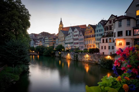 View in summer from the Neckar bridge onto the Neckar front with historic buildings, collegiate