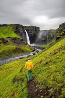 Hikers in a green canyon, Haifoss and Granni waterfall at a canyon, Fossá í Þjórsárdal, with river