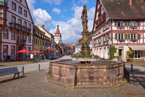 Market fountain on the market square with half-timbered house and Niggel tower in Gengenbach, Black