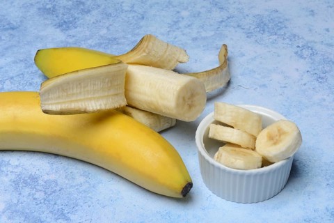 Opened banana and banana slices in peel