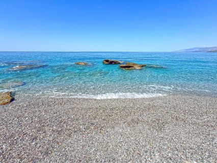 Fine pebble beach with small pebbles stones behind turquoise blue sea sea water calm sea bathing