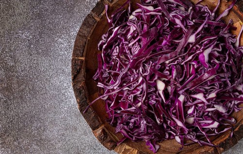 Red cabbage, sliced, in a wooden salad bowl, top view, no people