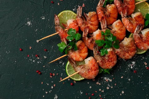 Garnelenspieß, mit Gewürzen, Limette, auf Holzspießchen, Ansicht von oben, ohne Personen